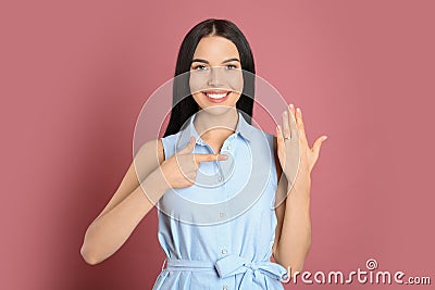 Happy young woman wearing beautiful engagement ring on pink background Stock Photo