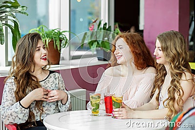 Happy young women chatting in a cafe. Laughter. The concept of friendship, meeting Stock Photo