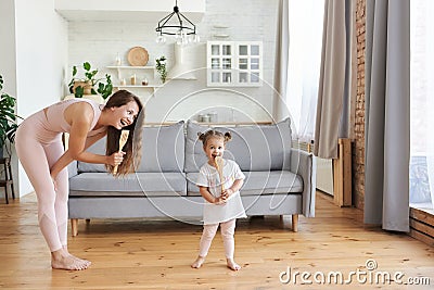 Happy young woman and her small daughter as a microphones singing songs having fun Stock Photo