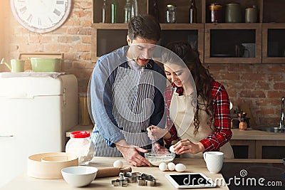 Happy young couple baking in loft kitchen Stock Photo