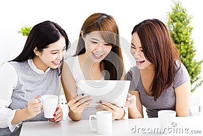 happy young women watching tablet in living room Stock Photo