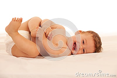 Hapy baby boy in playing on bed isolated over white Stock Photo