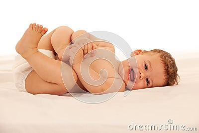 Hapy baby boy in playing on bed isolated over white Stock Photo