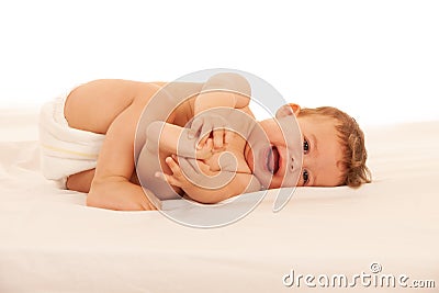 Hapy baby boy in playing on bed isolated over white Stock Photo