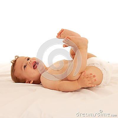 Hapy baby boy in playing on bed isolated over white Stock Photo