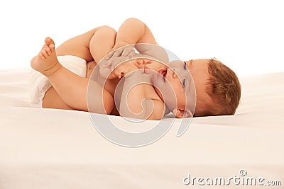 Hapy baby boy in playing on bed isolated over white Stock Photo