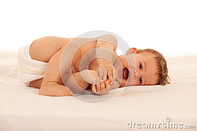 Hapy baby boy in playing on bed isolated over white Stock Photo