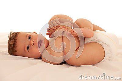 Hapy baby boy in playing on bed isolated over white Stock Photo