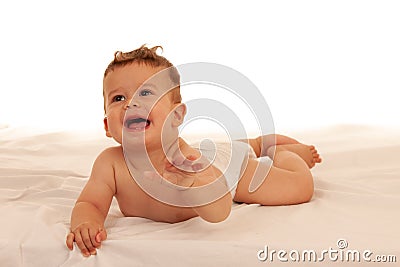 Hapy baby boy in playing on bed isolated over white Stock Photo