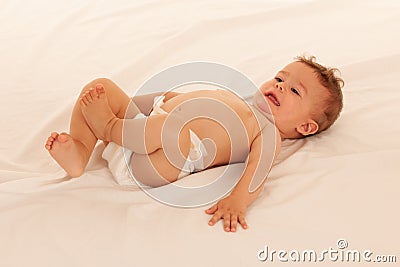 Hapy baby boy in playing on bed isolated over white Stock Photo