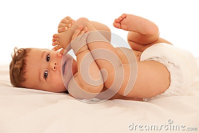 Hapy baby boy in playing on bed over white Stock Photo