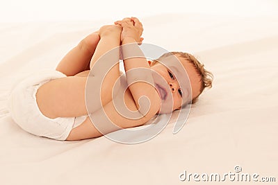 Hapy baby boy in playing on bed over white Stock Photo