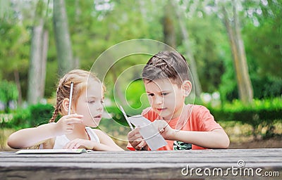 Hapy kids learn in a park. Brother and sister together do the j Stock Photo