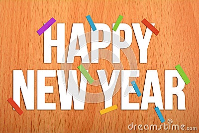 Hapy New Year on Wooden Background with colorful papers Stock Photo