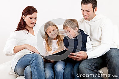 Hapy young family watching photo album Stock Photo