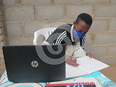 African school child wearing face mask learning using laptop. Editorial Stock Photo