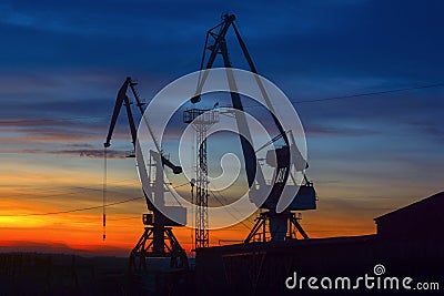 Harbor cranes and sky background during sunset. Stock Photo