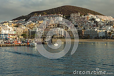 Harbor in Los Cristianos, Tenerife, Spain - May 25, 2019: On the left - fishing boats and tourist yachts early morning in the port Editorial Stock Photo