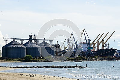 Harbor view with grain terminal silos, many shore cranes and bulk ship Stock Photo