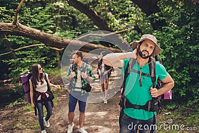 Hard, difficult, tiring and exhausting expedition of four friends in wild forest in trail. Guy is struggling of a neck pain, massa Stock Photo