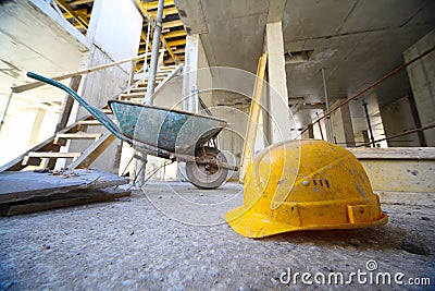 Hard hats and cart on concrete floor Stock Photo