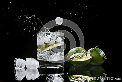 hard seltzer with lime on a dark wooden background, ice cubes fall into a glass with an alcoholic beverage hard seltzer Stock Photo