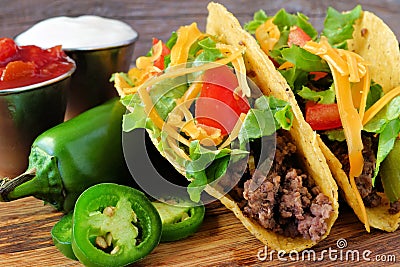 Hard shelled tacos with ground beef, lettuce, tomatoes, cheese close-up Stock Photo