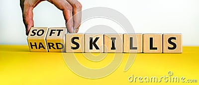 Hard skills versus soft skills. Hand flips cubes and changes the expression `hard skills` to `soft skills` or vice versa. Stock Photo