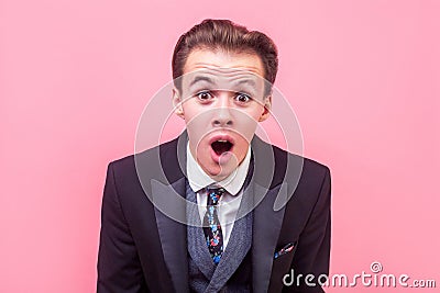 Hard to believe! Portrait of surprised young businessman staring at camera with shocked expression. studio shot isolated on pink Stock Photo