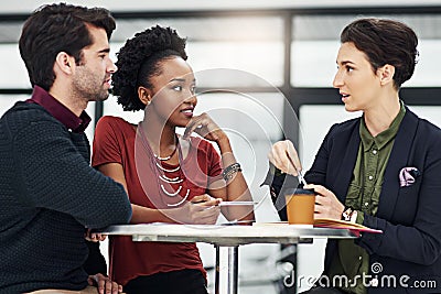 When hard work meets focus, success is guaranteed. a group of businesspeople meeting around a small table in their Stock Photo