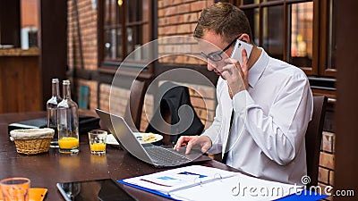 Hard working businessman in restaurant. Stock Photo