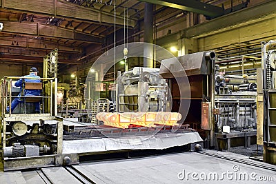 Hardening of steel components in a foundry - red-hot components come out of the oven Stock Photo