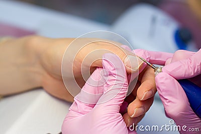 Hardware Manicure using electric device machine. procedure for the preparation of nails before applying nail polish. Hands of Stock Photo
