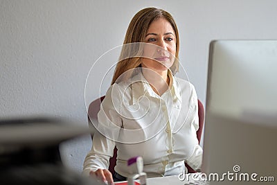 Hardworking businesswoman concentrating on her work as she sits at a computer Stock Photo