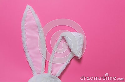 Hare ears made of white fur on pink pastel background. The concept of Easter Stock Photo