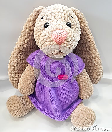 Hare with long ears, hare in a dress, lilac, brown, knitted, manual Stock Photo