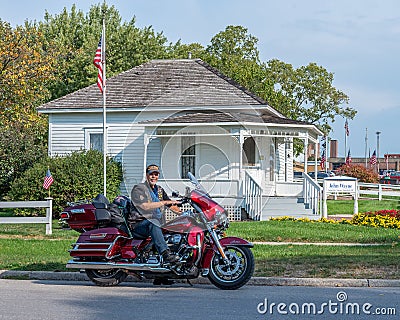 A Harley biker vacationer stops to visit the modest home where John Wayne was born Marion Robert Morrison on May, 26, 1907 Editorial Stock Photo