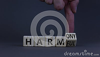 From harmful to harmony. Businessman turns the wooden cube and changes word harmful to harmony. Beautiful grey table, grey Stock Photo