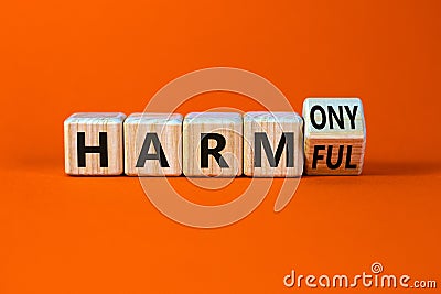 From harmful to harmony symbol. Turned a wooden cube and changed word harmful to harmony. Beautiful orange table, orange Stock Photo