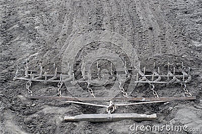 Harrow. Ancient iron plow on the earth. Stock Photo