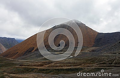 Harsh mountain landscape with road serpentine at the top of the pass Stock Photo