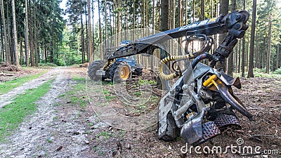 Harvester near a forest path in a sunny summer day Stock Photo