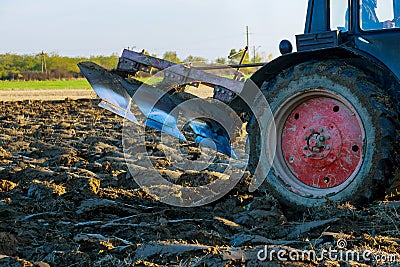 After harvesting the autumn field, the tractor ploughs it with its plow Stock Photo