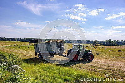 Kaluzhskiy region, Russia - June 2018: Harvesting of bales with agricultural equipment Editorial Stock Photo