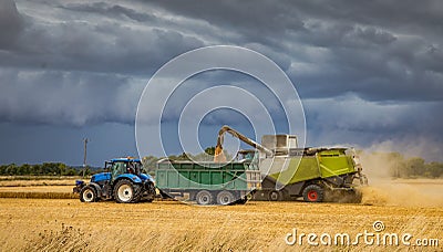 Harvesting under a very stormy looking sky. Stock Photo
