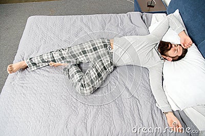 It has been a long night. mature male with beard in pajama on bed. asleep and awake. energy and tiredness. bearded man Stock Photo