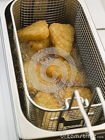 Hash Browns being Deep Fried in Corn Oil Stock Photo