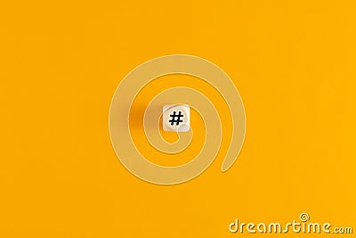 Hashtag symbol on wooden cube against yellow background. Overhead view with copy space Stock Photo