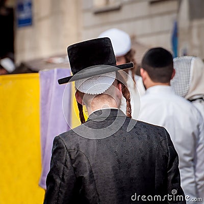 Hasid in a traditional hat on the street in a crowd of pilgrims. Rosh Hashanah, Jewish New Year. Editorial Stock Photo