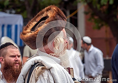 Hasid in the traditional headgear shtreimel on the street in a crowd of pilgrims. Rosh Hashanah, Jewish New Year Editorial Stock Photo